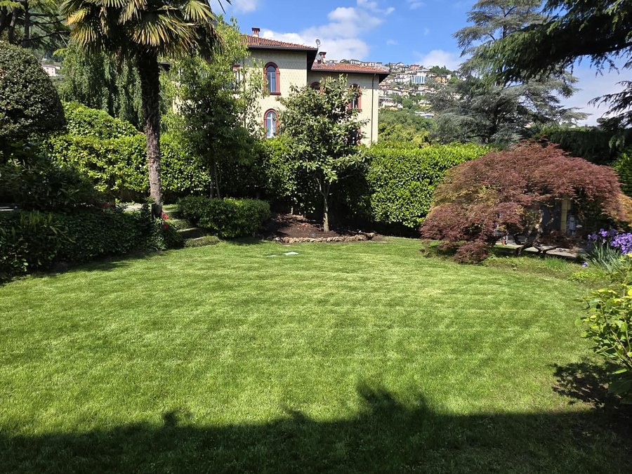 Giardino di villa a Como con prato a strisce e siepi in forma